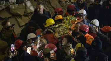 Petugas penyelamat mengangkat tandu yang membawa Seher, seorang gadis Suriah berusia 15 tahun di Hatay, tenggara Turki, pada 14 Februari 2023. Saher berhasil diselamatkan setelah terperangkap di bawah reruntuhan selama 210 jam seminggu setelah gempa mematikan melanda sebagian dari Turki dan Suriah. (AFP/Yasin AKGUL)