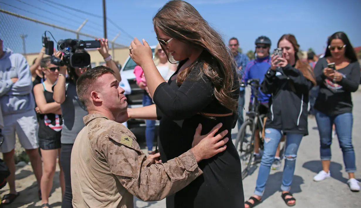 Angkatan Laut AS melepas kerinduan bersama keluarga saat tiba di Camp Pendleton di Oceanside, California, AS, Kamis (11/5). Unit Ekspedisi Kelautan 11  telah menjalani tugas ke sejumlah negara selama 7 bulan. (AFP/ Sandy Huffaker)