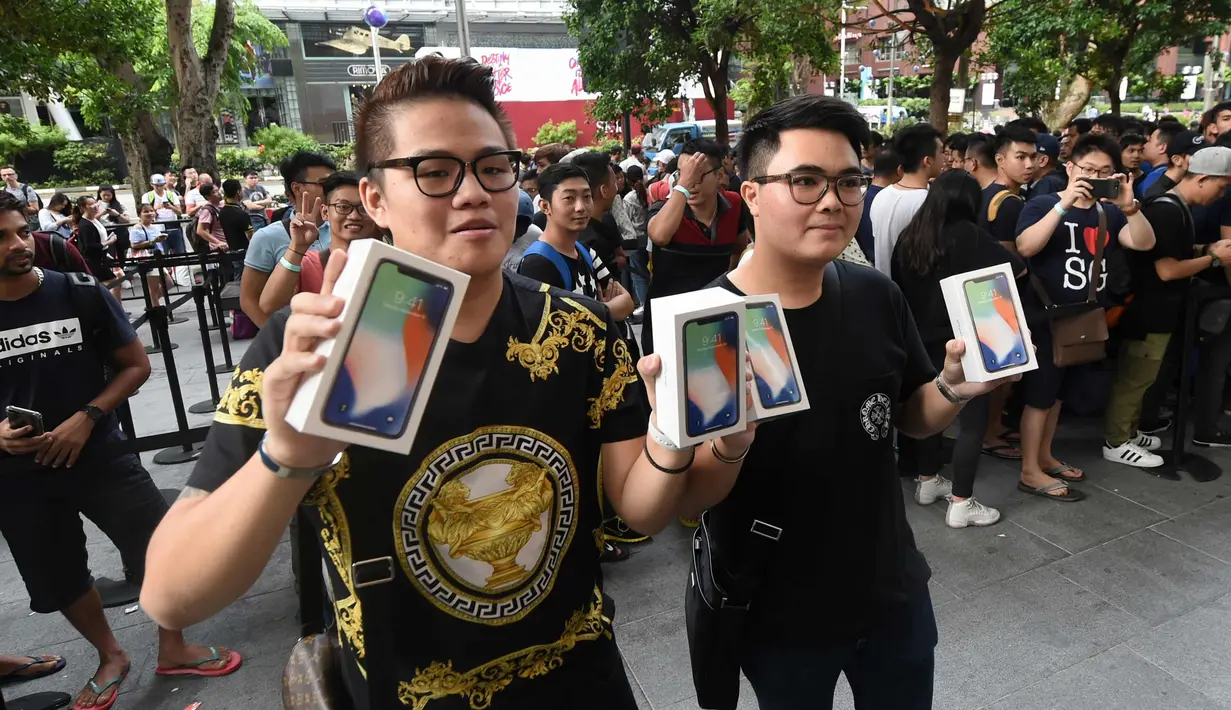 Pelanggan pertama menunjukkan iPhone X setelah ia membelinya di Singapura (3/11). (AFP Photo/Roslan Rahman)