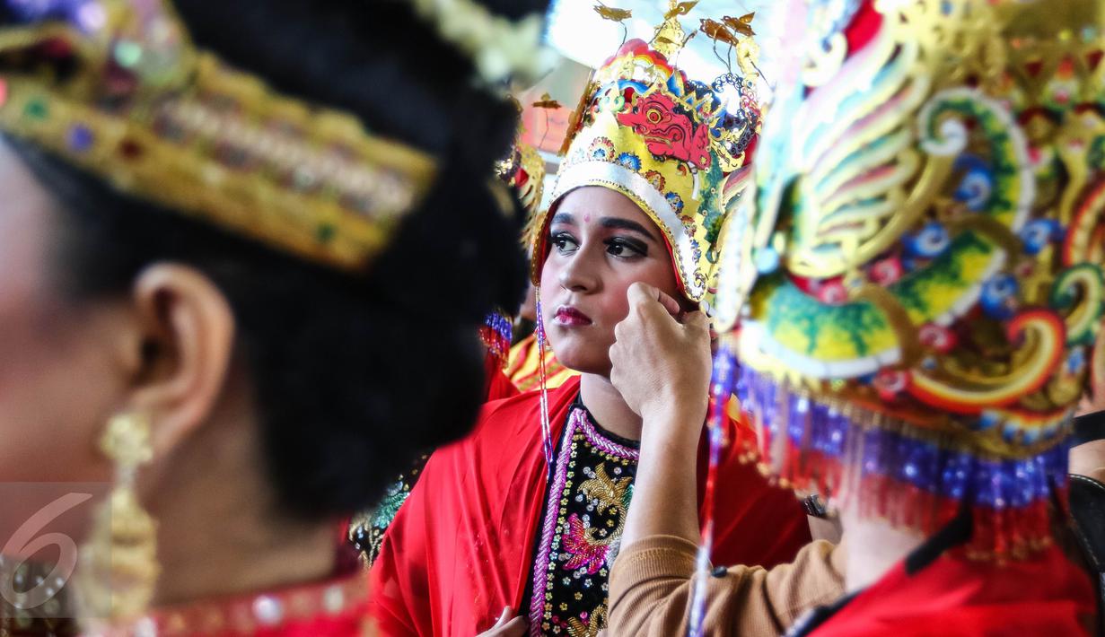 Seorang penari sedang memperbaiki mahkota di balik panggung Pentas Budaya di Terminal 3 Bandara Seokarno Hatta, Tangerang, Banten Senin (15/08). (Liputan6.com/Fery Pradolo)