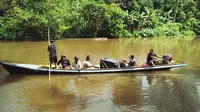 Polisi dan petugas menyalurkan logistik Pilkada dengan bertaruh nyawa di sungai menggunakan sampan tanpa motor agar hak masyarakat terpenuhi. (foto : Liputan6.com / M Syukur)