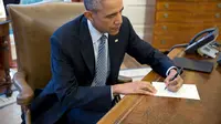 Presiden Obama saat menulis surat balasan untuk Ileana Yarza di Ruang Oval, Gedung Putih. (whitehouse.gov)