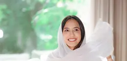 Penampilan Pevita Pearce di foto ini bisa kamu jadikan inspirasi outfit bukber. Ia tampil mengenakan gamis lengan pendek yang mengkilap, menambah nuansa mewah pada tampilan yang sederhana. Pevita menambahkan selendang putih polos untuk menutupi kepalanya. [Foto: Instagram/pevpearce]