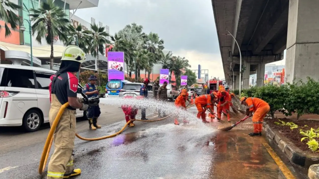 Petugas gabungan membersihkan material pascabanjir yang terjadi di sepanjang Jalan Boulevard Raya, Kelurahan Kelapa Gading Timur, Kecamatan Kelapa Gading, Jakarta Utara pada Senin (19/1/2026).