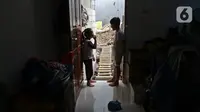 Dua orang anak bermain di depan pintu rumahnya yang terhimpit bangunan gudang di kawasan Mangga Dua Dalam, Jakarta, Kamis (12/12/2019). (Liputan6.com/Herman Zakharia)