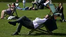 Seorang pria tampak bersantai menikmati sinar matahari di atas kursi di sebuah taman di London, Inggris, Rabu (4/5). Awal Mei, suhu udara hangat mulai menyelimuti kota London. (REUTERS/Neil Hall)