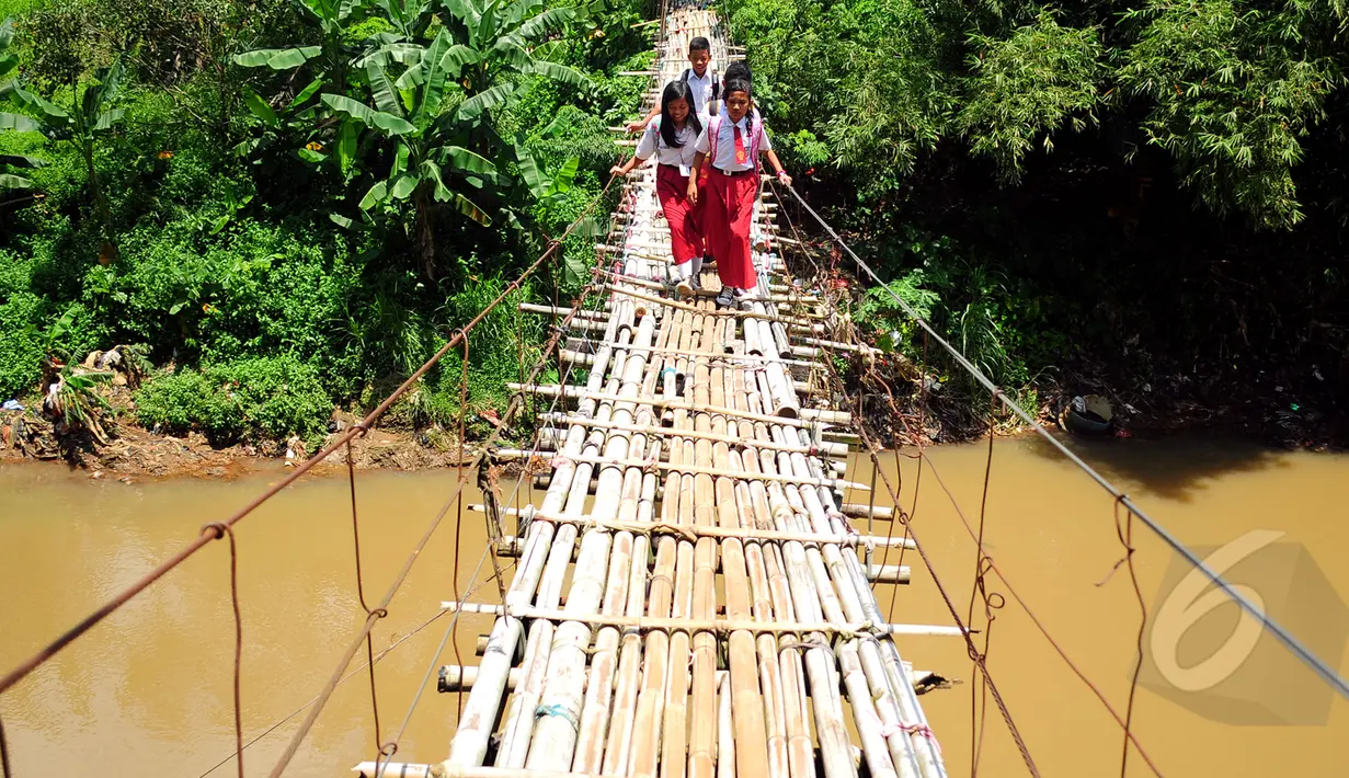 Sejumlah siswa SD harus melewati jembatan gantung beresiko di atas kali Ciliwung untuk menuju ke sekolah, Jakarta, Selasa (17/3/2015). Jembatan tersebut menghubungkan Kelapa Dua Depok dengan Lenteng Agung (Liputan6.com/Yoppy Renato)