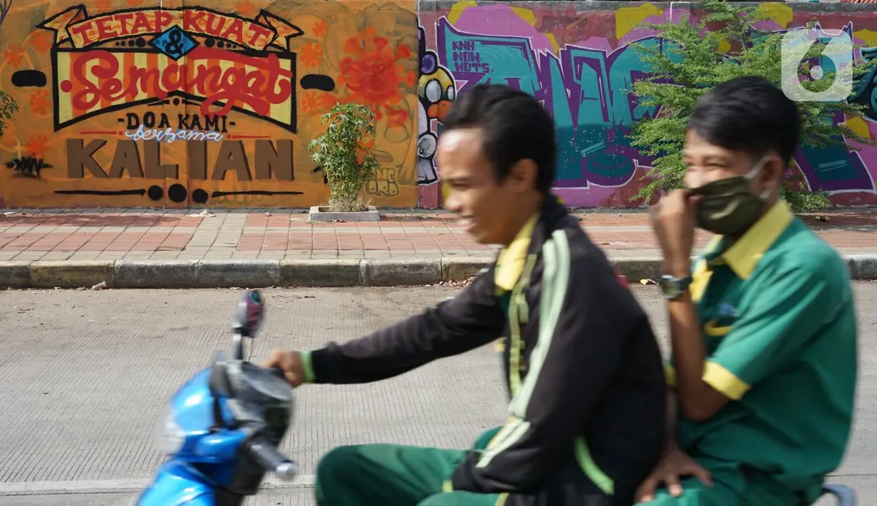 Pengendara sepeda motor melintas di depan mural bertema pandemi virus corona COVID-19 di kawasan Sunter, Jakarta, Selasa (2/6/2020). Mural tersebut dibuat sebagai wujud dukungan terhadap tenaga medis serta masyarakat agar tetap semangat menghadapi pandemi COVID-19. (Liputan6.com/Immanuel Antonius)