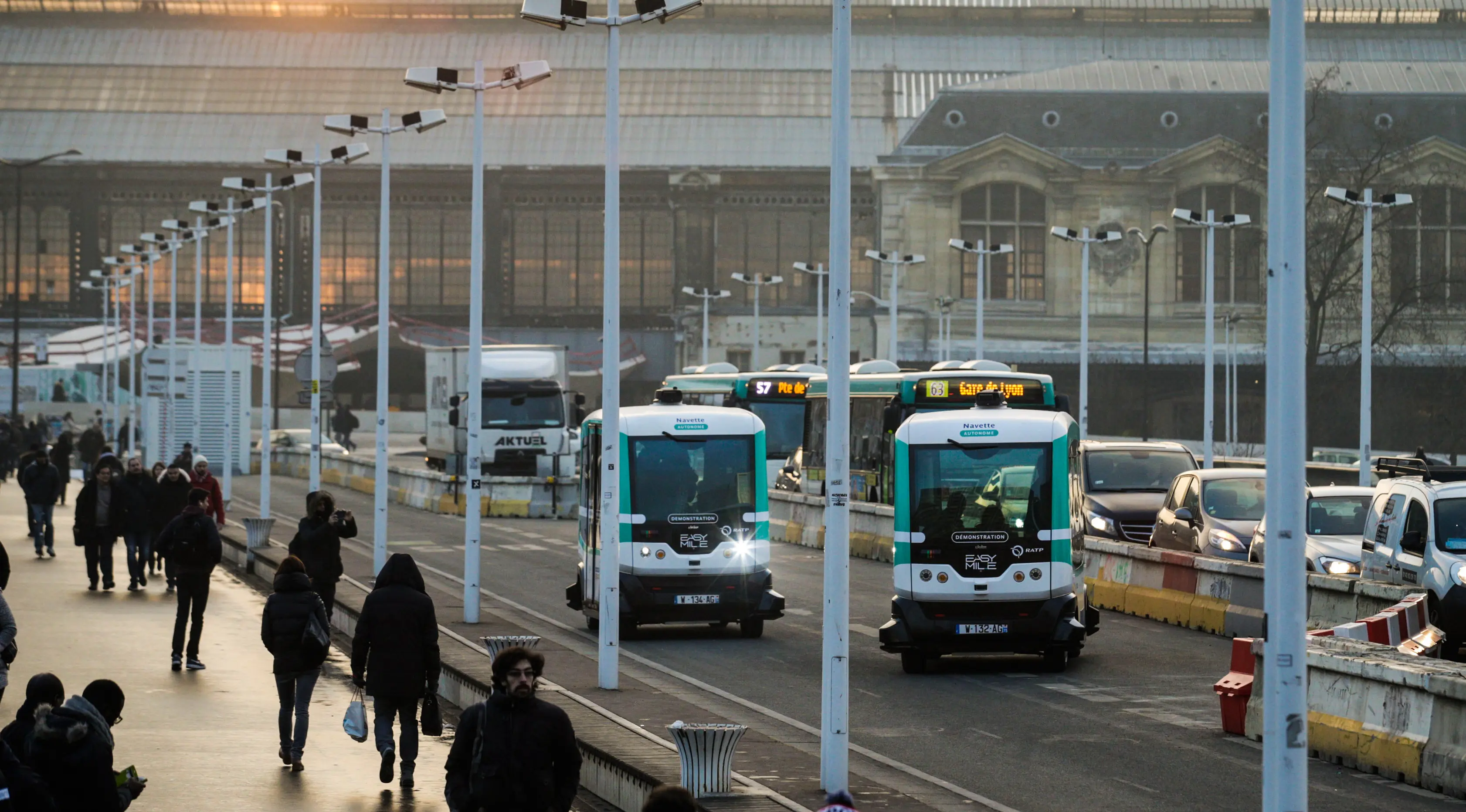 Dua bus tanpa supir (driverless) yang mulai dioperasikan di Paris, Senin (23/1). Bus listrik berbentuk kotak tersebut dilengkapi dengan laser dan kamera untuk mendeteksi objek lain dan orang di sekitarnya. (GEOFFROY VAN DER HASSELT/AFP)