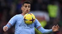 Bek Manchester City, Joao Cancelo mengontrol bola saat menghadapi Manchester United dalam laga Liga Inggris 2022/2023 di Old Trafford Stadium, Manchester (14/1/2023). Joao Cancelo menjadi pemain terbaru yang hengkang setelah berkonflik dengan Pep Guardiola di Manchester City. Pada bursa transfer Januari 2023 bek kanan Portugal tersebut memilih dipinjamkan ke Bayern Munchen dengan opsi dipermanenkan akibat tak jadi pilihan utama lagi dalam beberapa laga terakhir. (AFP/Oli Scarff)