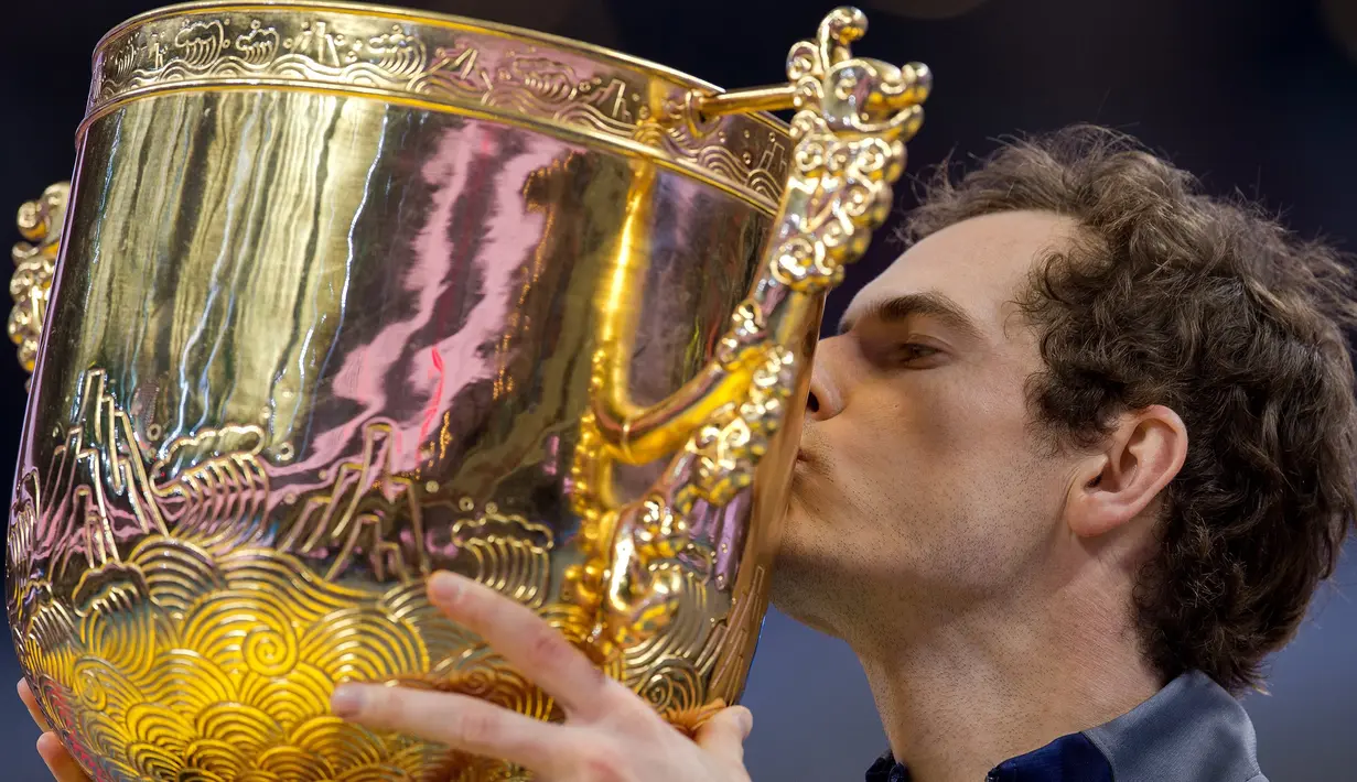 Petenis Inggris Raya, Andy Murray mencium trofi sebagai juara turnamen China Open setelah mengalahkan petenis Bulgaria Grigor Dimitrov, di Beijing, Minggu (9/10). Titel tersebut diraih usai melakoni duel selama satu jam 57 menit. (NICOLAS ASFOURI/AFP)