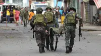 Sejumlah tentara membawa rekannya usai bom rakitan meledak dekat kendaraan militer di Kota Jolo, Pulau Sulu, Filipina, Senin (24/8/2020). Sebanyak 10 orang tewas dan puluhan lainnya terluka -banyak dari mereka tentara atau polisi- dalam pemboman ganda tersebut. (Nickee BUTLANGAN/AFP)