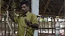 Kali memegang seekor kobra tangkapannya di pusat ekstraksi bisa ular Irula di pinggiran Chennai, India, (11/11). Berbekal sabit kecil, linggis, dan tas kanvas, Kali dan rekannya Vedan setiap hari memburu kobra. (AFP Photo/Arun Sankar)