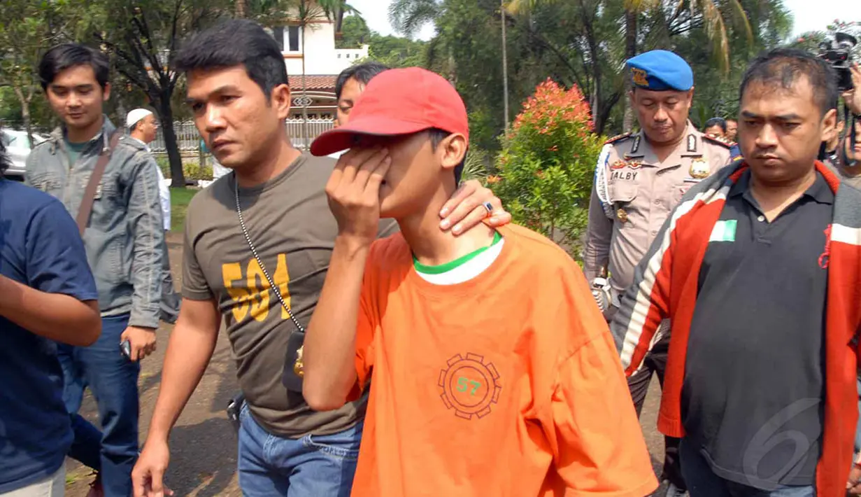 Pemuda berusia 20 tahun tersebut terlihat menutupi wajahnya dari sorotan kamera. (Liputan6.com/Miftahul Hayat)