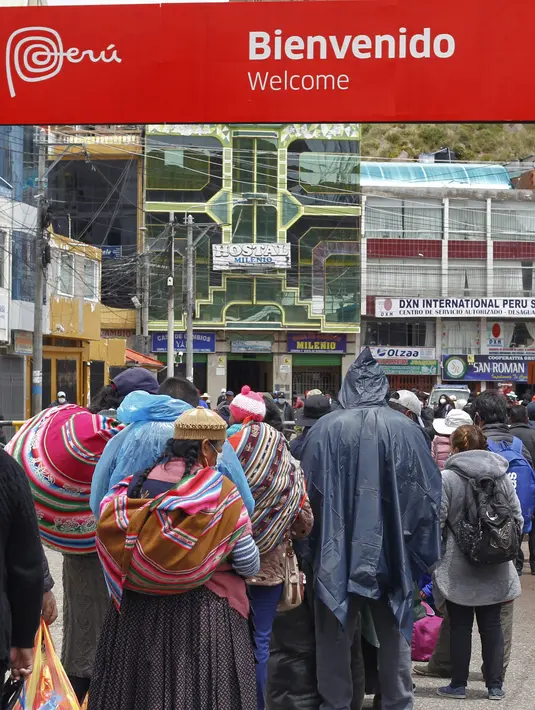 Warga Peru antre masuk ke perbatasan Bolivia untuk memasuki negara tersebut, di desa Desaguadero, Peru, pada 18 Februari 2022. Setelah ditutup selama hampir dua tahun karena pandemi Covid-19, Peru mengizinkan pembukaan kembali perbatasan dengan Bolivia dan Ekuador. (Carlos MAMANI/AFP)