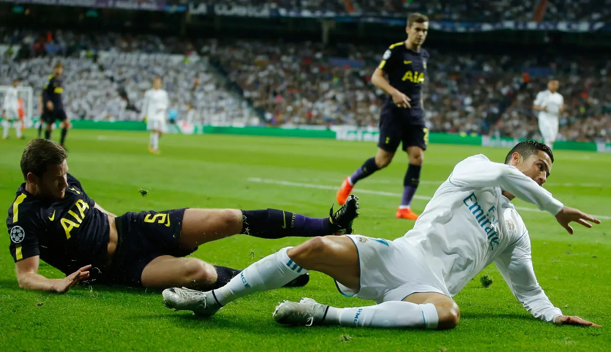 Pemain Real Madrid, Cristiano Ronaldo dan pemain Tottenham Hotspur, Jan Vertonghen terjatuh selama laga lanjutan fase Grup H Liga Champions di Santiago Bernabeu, Selasa (17/10). Madrid berbagi angka dengan Tottenham 1-1.  (AP/Francisco Seco)