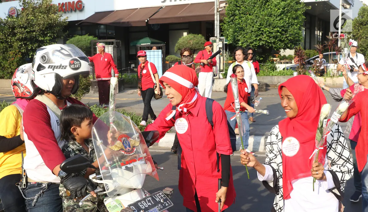 Relawan Jokowi saat membagikan bunga mawar kepada pengendara motor di Kawasan Sarinah, Jakarta, Minggu (29/9/2019). Aksi bagi bunga tersebut merupakan aksi damai kami bersama Jokowi. (Liputan6.com/Angga Yuniar)
