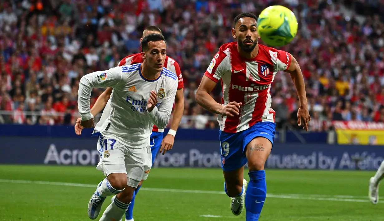 <p>Pemain depan Real Madrid Lucas Vazquez (kiri) berebut bola dengan penyerang Atletico Madrid Matheus Cunha dalam laga pekan ke-35 Liga Spanyol di Wanda Metropolitano, Senin (9/5/2022) dini hari WIB. Atletico Madrid berhasil menang dengan skor tipis 1-0 atas Real Madrid. (GABRIEL BOUYS / AFP)</p>
