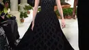 Model Bella Hadid berjalan di atas catwalk mengenakan koleksi terbaru dari Oscar de la Renta dalam New York Fashion Week, AS (12/2). Bella Hadid tampil cantik dengan gaun hitam panjang tanpa lengan. (AFP Photo/Slaven Vlasic)