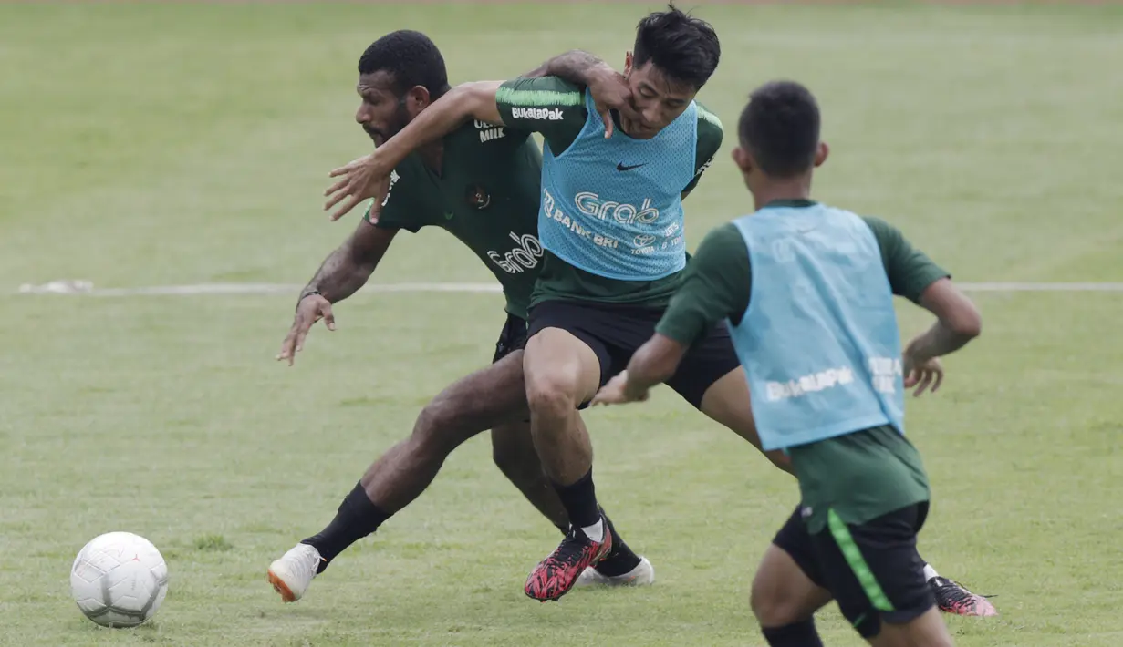 Pemain Timnas Indonesia U-22, Marinus Wanewar, berebut bola dengan Hanif Sjahbandi saat latihan di Stadion Madya, Jakarta, Selasa (15/1). Latihan ini merupakan persiapan jelang Piala AFF U-22. (Bola.com/Yoppy Renato)