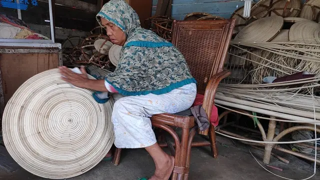 Pengrajin rotan di Pekanbaru tengah menghaluskan tameng pesanan konsumen.
