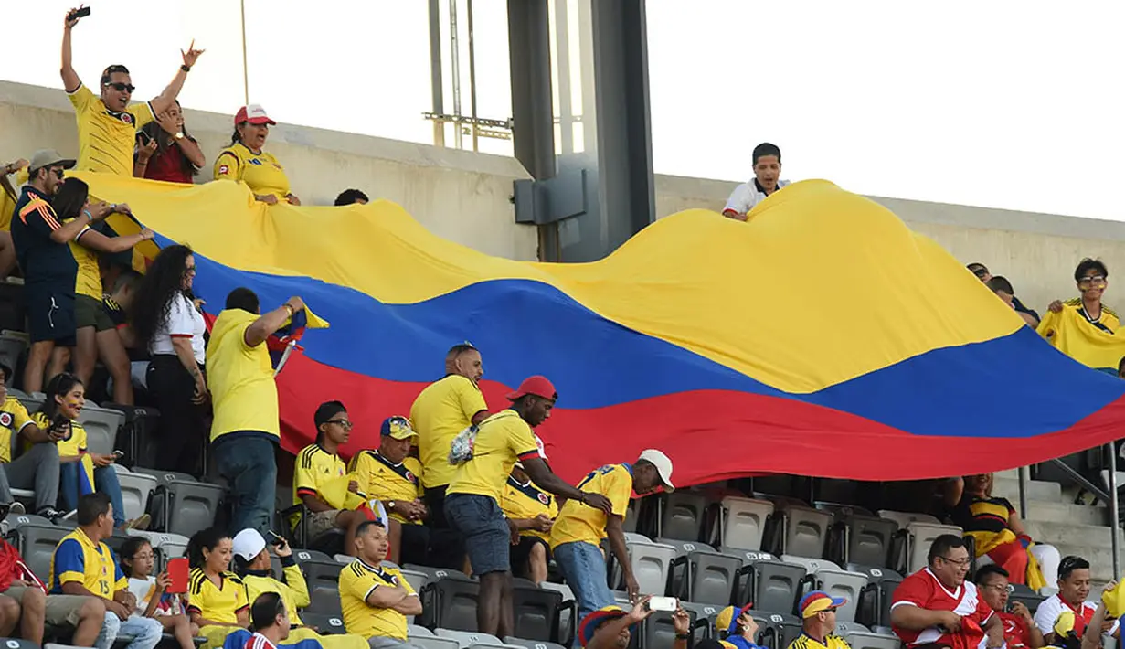 Suporter Kolombia membentangkan bendera raksasa saat laga perempat final Copa America Centenario melawan Peru. Kedua tim bermain imbang hingga laga ditentukan melalui adu penalti. (AFP/Don Emmert)