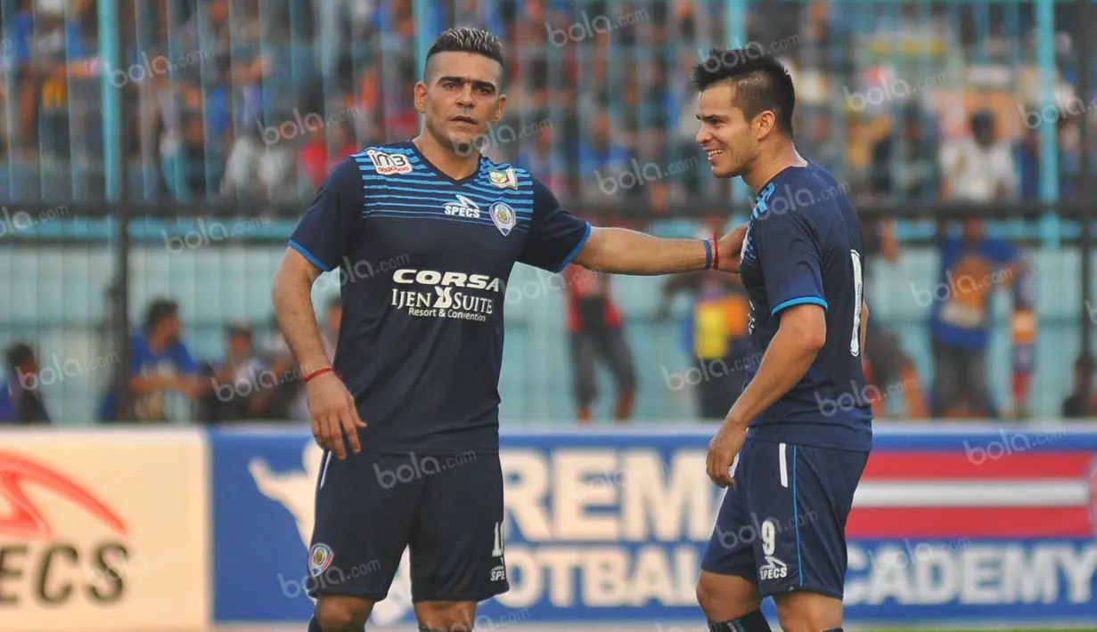 Striker seleksi Arema asal Australia, Gustavo Giron (kanan), akrab dengan Cristian Gonzales dalam laga uji coba melawan Persija di Stadion Kanjuruhan, Malang, Sabtu, (16/4/2016). (Bola.com/Iwan Setiawan)