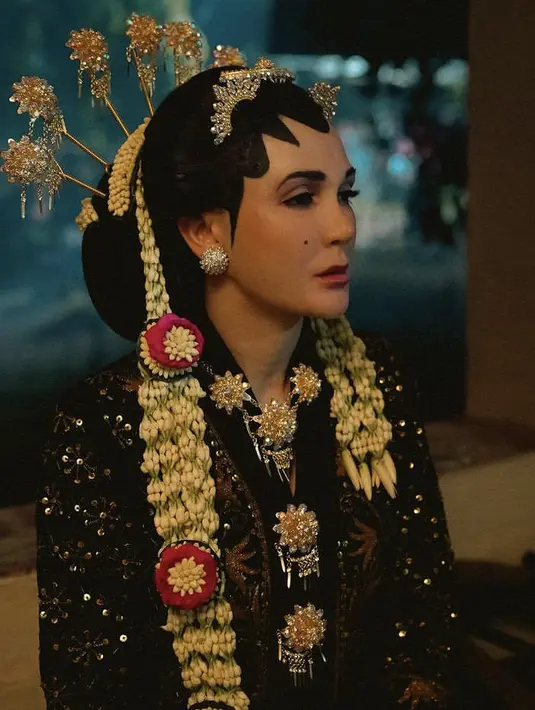 Luna tampil dengan kebaya pengantin khas Jawa warna hitam dengan aksen detail keasaman, lengkap dengan bros dan kalung model bunga keemasan.  [@lunamaya]