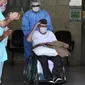 Veteran Perang Dunia II asal Brasil, Ermando Armelino Piveta meninggalkan Rumah Sakit Angkatan Bersenjata setelah pulih dari covid-19 di Brasilia, Selasa (14/4/2020). Kakek berusia 99 tahun itu dinyatakan sembuh dari virus Corona setelah dirawat selama delapan hari. (EVARISTO SA/AFP)