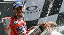 Pebalap Ducati, Andrea Dovizioso, merayakan keberhasilannya meraih gelar juara balapan MotoGP Italia di Sirkuit Mugello, Minggu (4/6/2017). Dovizioso menjadi yang tercepat dengan waktu 41 menit 32,126 detik.(AFP/Vincenzo Pinto)