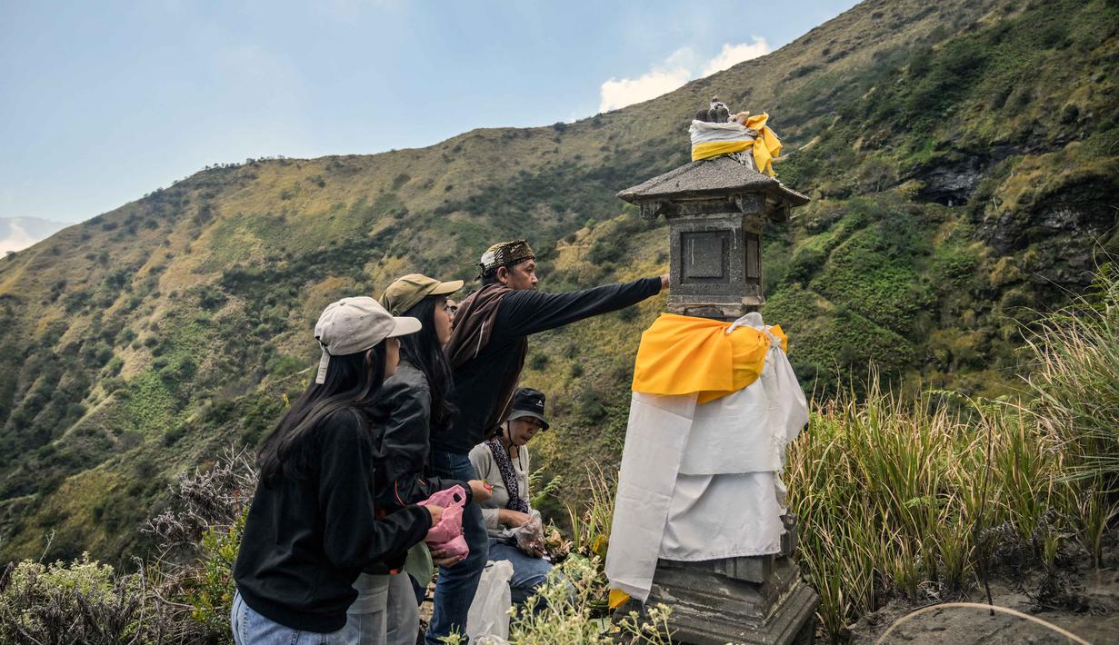 Orang-orang berdoa dan memberkati di bukit Widodaren menjelang upacara Yadnya Kasada di Pasuruan, di kaki Gunung Bromo, Jawa Timur, pada Minggu 31 Mei 2026. (JUNI KRISWANTO/AFP)