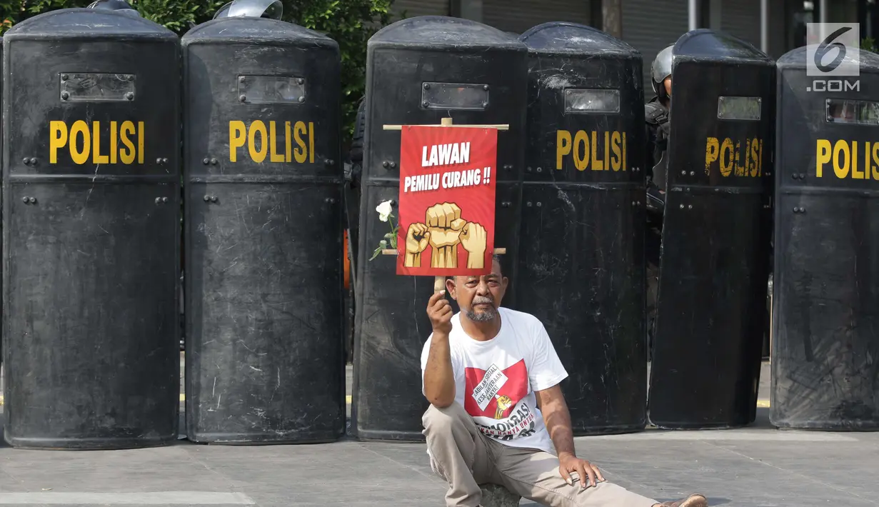 Salah satu peserta aksi massa Gerakan Nasional Kedaulatan Rakyat saat melakukan unjuk rasa di depan Gedung Bawaslu, Jakarta, Selasa (21/5). Mereka menolak hasil Pemilu 2019 yang dinilai banyak terdapat kecurangan. (Liputan6.com/Helmi Fithriansyah)