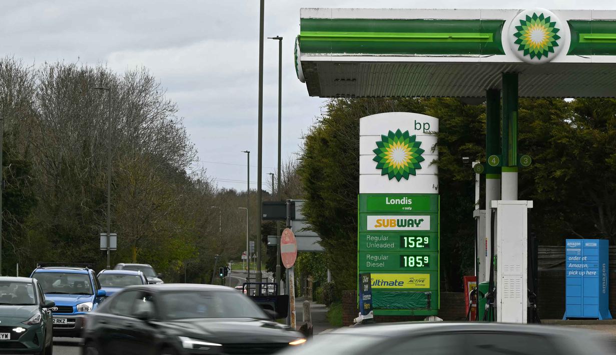 Jalur vital perdagangan energi dunia, Selat Hormuz, dilaporkan hampir terhenti imbas serangan udara Amerika Serikat dan Israel terhadap Iran pada akhir Februari 2026 lalu yang sekaligus memicu tekanan terhadap rantai pasok energi global. Tampak dalam foto, papan informasi digital menampilkan harga terbaru untuk satu liter bensin dan solar di sebuah Stasiun Pengisian Bahan Bakar Umum (SPBU), Guildford, barat daya London, pada 29 Maret 2026. (JUSTIN TALLIS/AFP)