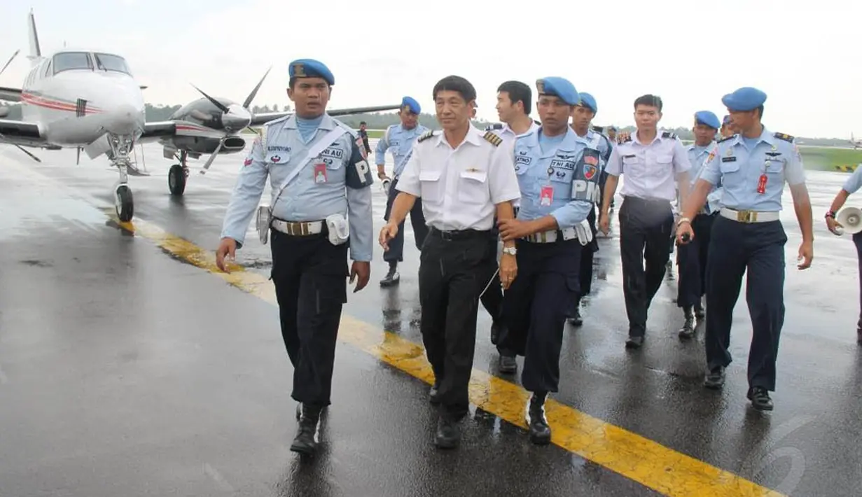 Anggota TNI AU menggiring tiga awak pesawat asing asal Singapura, sesaat setelah dipaksa mendarat di Lanud Supadio Pontianak, Kalimantan Barat, Selasa (28/10/2014). (Liputan6.com/Raden AMP)