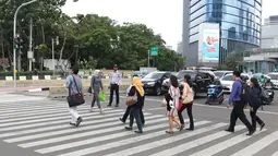 Petugas Dinas Perhubungan DKI Jakarta mengawasi warga yang menyebrang di kawasan Tosari, Jakarta, Jumat (14/12). Penggunaan pelican crossing di kawasan ini menggantikan fungsi JPO Tosari yang akan dibongkar. (Liputan6.com/Helmi Fithriansyah)