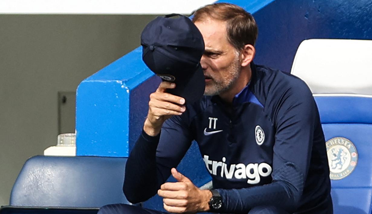 Pelatih Chelsea, Thomas Tuchel menutup wajahnya dari semburan sinar matahari dengan topinya saat memantau jalannya pertandingan pekan keenam Liga Inggris 2022/2023 antara Chelsea melawan West Ham United. (AFP/Adrian Dennis)