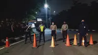 Petugas gabungan menjaga akses menuju Bandara Soekarno Hatta, Cengkareng. Polisi merekayasa lalu lintas menuju bandara tersebut jelang kepulangan pemimpin FPI Rizieq Shihab. (Liputan6.com/Pramita Tristiawati)