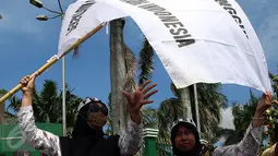 Dua guru membentangkan bendera saat unjuk rasa di depan Gedung DPR/MPR, Jakarta, Kamis (12/1). Mereka juga menuntut tunjangan sertifikasi bagi guru agama yang bernaung di Kemenag yang hingga kini belum terbayar. (Liputan6.com/Johan Tallo)