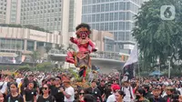 Umat Hindu mengarak ogoh-ogoh saat hari bebas berkendara di kawasan Bundaran HI, Jakarta, Minggu (12/3/2023). Pawai ogoh-ogoh tersebut diselenggarakan dalam rangka menyambut Perayaan Nyepi Tahun Baru Saka 1945/2023. (Liputan6.com/Angga Yuniar)