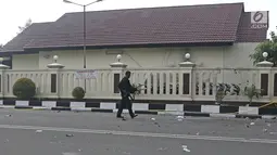 Aparat polisi bersenjata lengkap berjalan di depan Rutan Cabang Salemba Mako Brimob seusai operasi penanggulangan di Depok, Kamis (10/5). Setelah sekitar 34 jam, para napi terorisme yang membuat kerusuhan akhirnya menyerah. (Liputan6.com/Herman Zakharia)