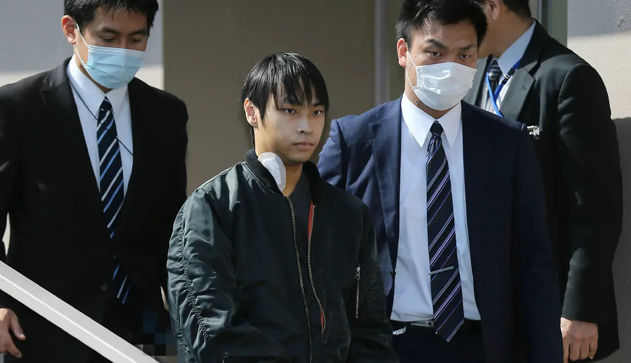Kabu Terauchi (kedua kiri) meninggalkan rumah sakit dengan pengawalan polisi di Izunokuni, Jepang, Kamis (31/3). Pria 23 tahun asal Nakano itu menculik dan menyekap gadis remaja (15) selama dua tahun di dalam apartemen miliknya. (JIJI PRESS/AFP)