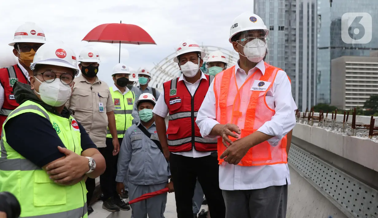 Menteri Perhubungan, Budi Karya Sumadi (kanan) saat meninjau Jembatan Bentang Panjang Dukuh Atas LRT Jabodebek, Jakarta, Minggu (29/11/2020). Saat ini progres pembangunan LRT Jabodebek sudah mencapai 79,52 persen dan ditarget akan beroperasi pada pertengahan 2022. (Liputan6/Helmi Fithriansyah)
