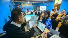 Petugas melayani orang tua calon siswa yang mencari informasi mengenai Sistem Penerimaan Murid Baru (SPMB) Tahun Ajaran 2026/2027 di Posko Pelayanan SPMB Suku Dinas Pendidikan Wilayah III yang berada di SMAN 70 Jakarta, Rabu (17/6/2026). (merdeka.com/Arie Basuki)