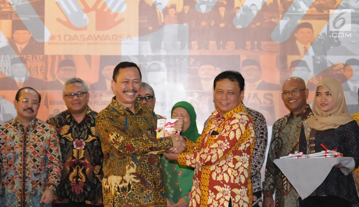 Ketua Bawaslu, Abhan (kedua kanan depan) menyerahkan buku perjalanan Bawaslu kepada Ketua Komnas HAM, Ahmad Taufan Damanik pada perayaan HUT 1 Dasawarsa Bawaslu di Jakarta, Senin (9/4). (Liputan6.com/Helmi Fithriansyah)