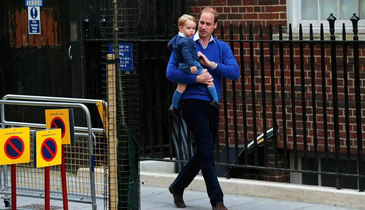 Pangeran William tampak menggendong putra pertamanya, George, menuju Lindo Wing RS St Mary, London, Sabtu (2/5/2015). George pertamakalinya diajak bertemu adik kecilnya yang baru lahir. (REUTERS/Suzanne Plunkett)