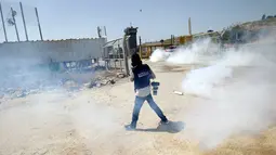 Seorang wartawan saat menghindari gas air mata yang ditembakkan pasukan Israel saat meliput aksi protes yang menyerukan pembebasan wartawan Palestina, Omar Nazzal di dekat Penjara Ofer Israel di Ramallah, Israel (26/4).(REUTERS / Mohamad Torokman)