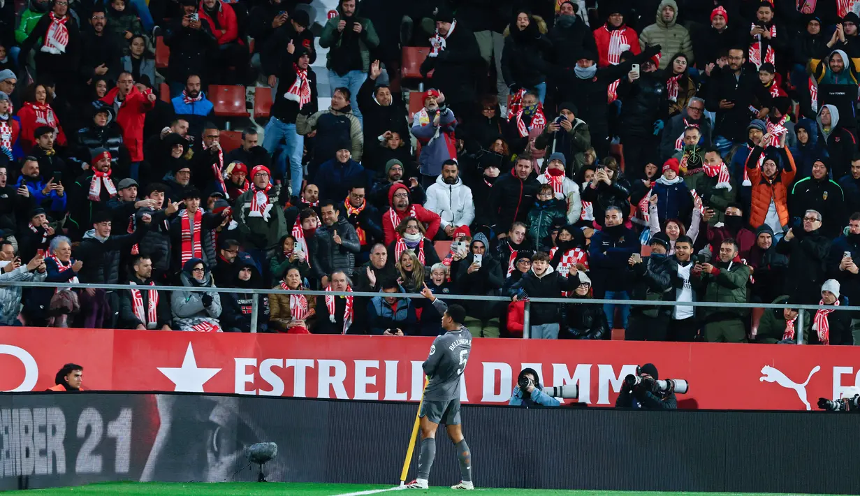 Pemain Real Madrid, Jude Bellingham, melakukan selebrasi di depan suporter Girona pada laga pekan ke-16 Liga Spanyol di Stadion Montilivi pada Sabtu (7/12/2024). (AP Photo/Joan Monfort)
