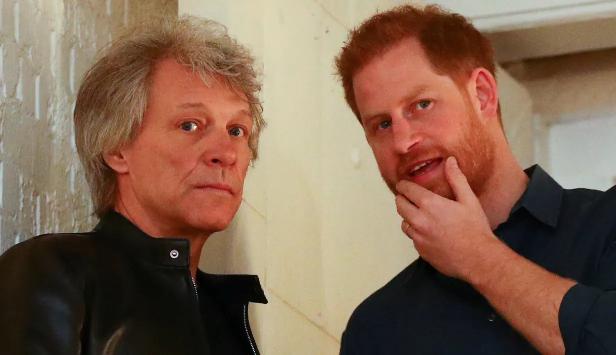 Pangeran Harry (kanan) berbincang dengan penyanyi AS, Jon Bon Jovi setibanya di Abbey Road Studios, London, Jumat (28/2/2020). Pentolan Bon Jovi dan Pangeran Harry akan bertemu dengan paduan suara Invictus Games untuk merekam lagu untuk amal. (HANNAH MCKAY / POOL / AFP)