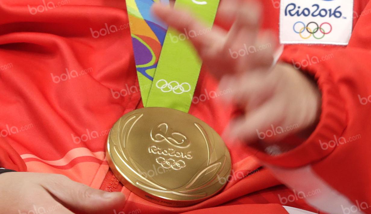 Medali emas bulutangkis Olimpiade Rio 2016 yang diraih Liliyana Natsir saat hadir dalam acara Liputan 6 SCTV di Studio SCTV, SCTV Tower, Jakarta, Kamis (25/8/2016). (Bola.com/Arief Bagus)