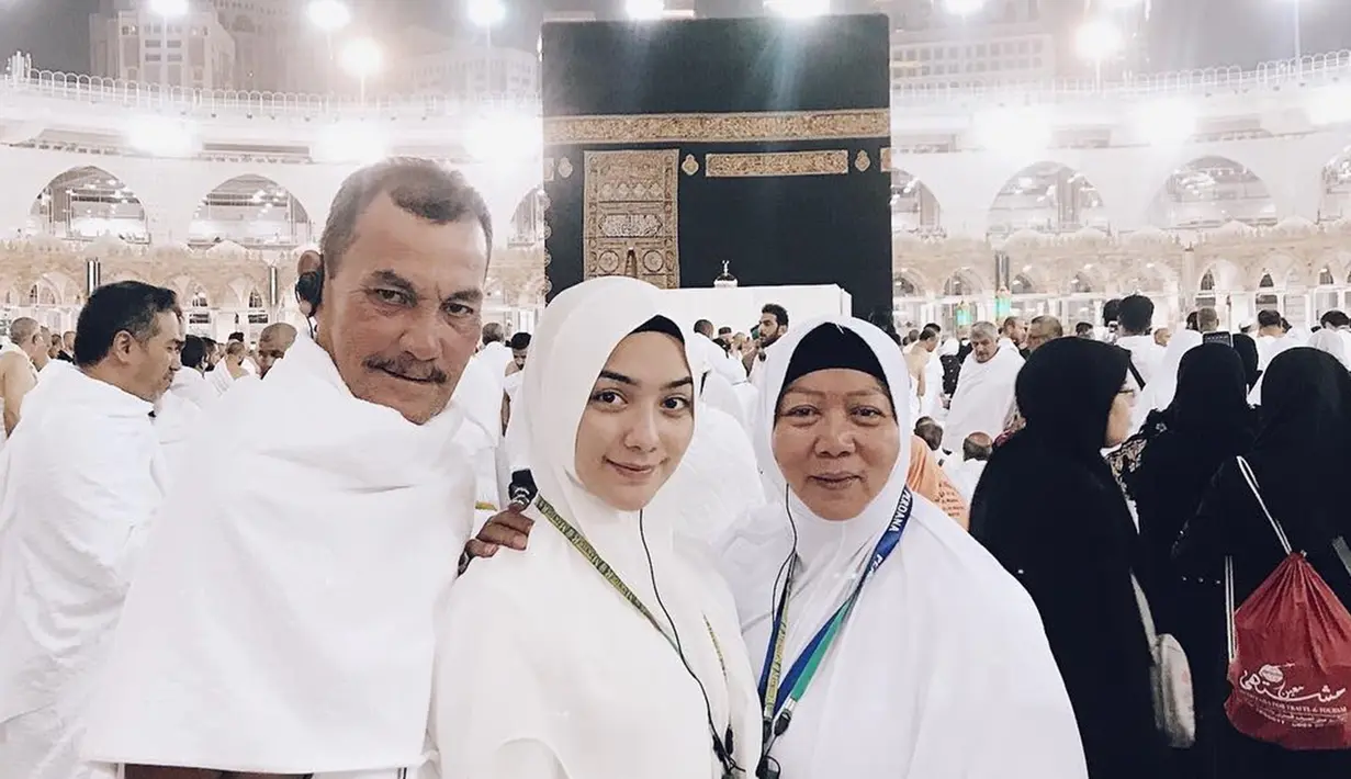 Citra Kirana bersama ayah dan ibu mengenakan pakaian serba putih, ketika menunaikan ibadah umroh di Tanah Suci yang sedang berada di depan Kabah. (Liputan6.com/IG/@citraciki)